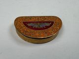 an image of a gold and red box sitting on top of a white table