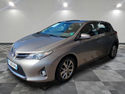 La Toyota Corolla est garée dans une pièce dont le sol est en damier.
