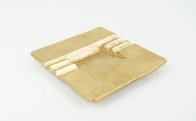 gold plate with a plane on it sitting on a white surface