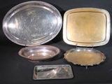 three silver trays and a silver tray on a black surface