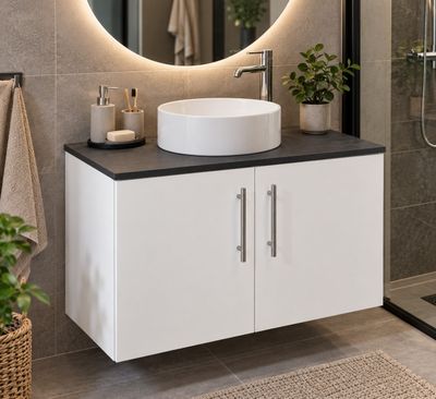 un lavabo blanc placé sous un miroir rond dans une salle de bains