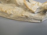 une statue représentant une main tenant une banane posée sur une table