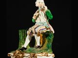 a figurine of a man sitting on a bench