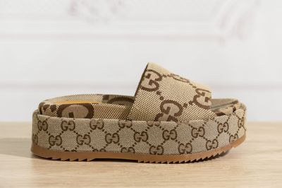 un gros plan sur une paire de Gucci posée sur une surface en bois