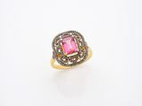 gros plan d'une bague en diamant rose et blanc sur une surface blanche