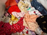 a pile of clothes that is on a bed