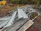 a pile of metal items on the ground in front of a fence