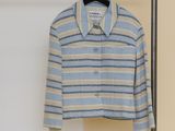 une photo d'une chemise à rayures bleues et blanches suspendue à un portant