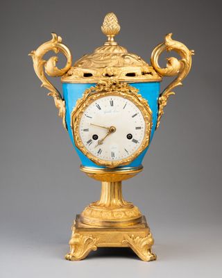 un vase doré et bleu orné d'une horloge