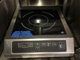 une cuisinière sur laquelle est posée une marmite dans une cuisine