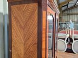 a wooden cabinet with a glass door in a room