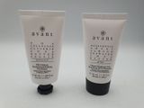 two tubes of hand cream sitting on top of each other
