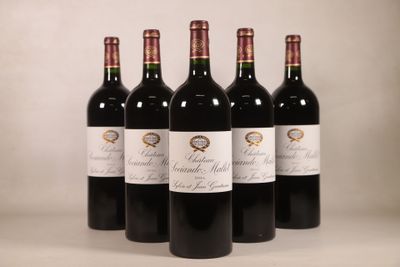 quatre bouteilles de vin rouge sont alignées sur une table