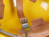 a yellow hard hat with a leather strap on it