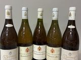 six bottles of wine are lined up on a table