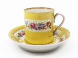 une tasse et une soucoupe jaunes posées sur une assiette blanche