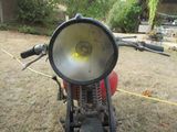 a motorcycle that is parked in the grass with a light on it