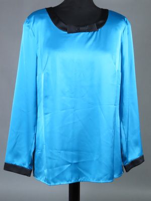 un chemisier bleu avec des bordures noires sur un mannequin, un mannequin, un mannequin, un mannequin, un mannequin, un mannequin, un mannequin, un mannequin, un mannequin