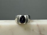 a close up of a silver ring with a black stone in the middle