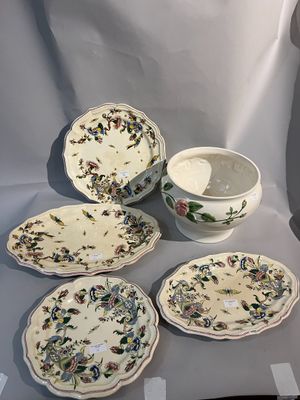 Plusieurs assiettes et bols sont posés sur une table devant un fond blanc.