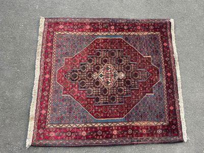 a red rug with a medallion design on the middle of it
