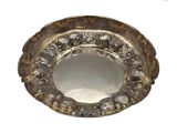 une assiette en argent ornée d'un motif sur fond blanc
