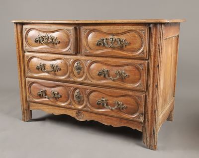 une vieille commode en bois ornée de sculptures et de poignées décoratives