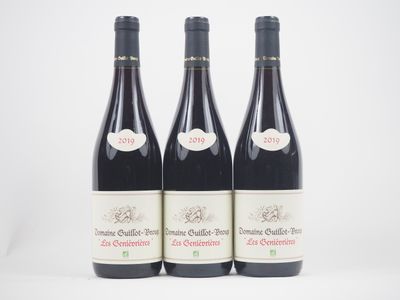 trois bouteilles de vin rouge posées l'une à côté de l'autre sur une surface blanche