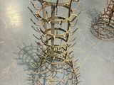 a metal sculpture of a wine rack on the floor
