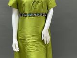 a mannequin wearing a green dress with beading on the neck