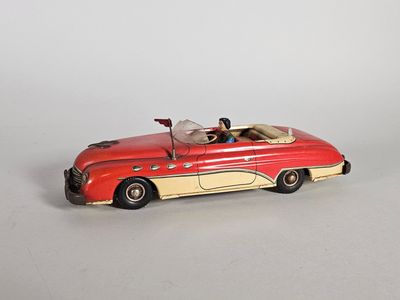 une petite voiture rouge posée sur une surface blanche