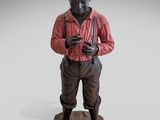 statue d'un homme portant un chapeau et une chemise rouge, debout sur un rocher