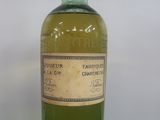 an old bottle of green liquid sitting on a black surface