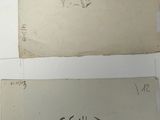 two pieces of paper with writing on them sitting on top of a table