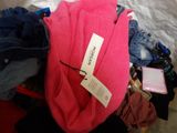 a pile of clothes on a bed with a tag on it