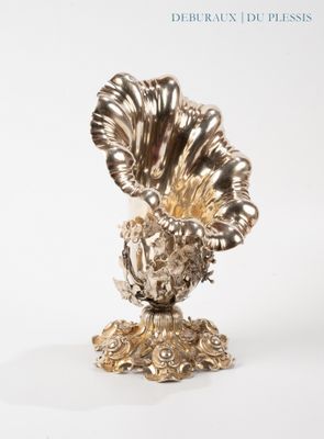 a silver vase with a large flower on top of it
