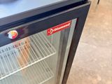 a small refrigerator that has a towel on top of it