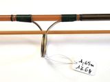 a close up of a pair of fishing rods on a white surface
