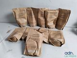 several bags of coffee sit on a table next to a cup of coffee