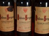 three bottles of red wine are lined up on a table