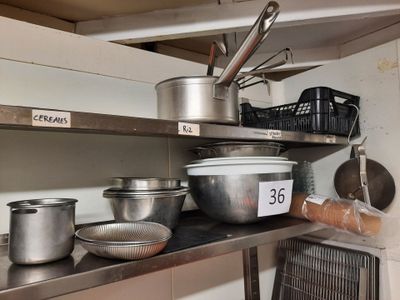 de nombreuses casseroles et poêles sur l'étagère de la cuisine