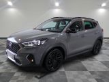 un SUV gris garé sur un sol à damier dans un garage