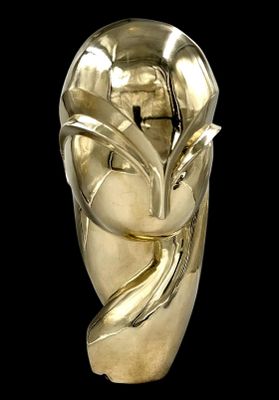 une sculpture en or représentant le visage d'une femme sur fond noir