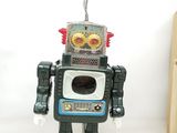 a toy robot that is standing next to a book