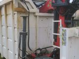 a white dumpster with a red and black machine inside of it