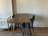 a table and chairs in a room with a white wall