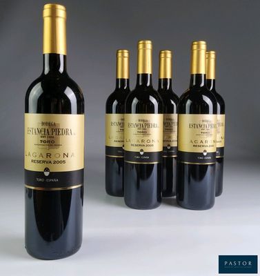 quatre bouteilles de vin rouge sont alignées sur une table