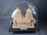 une petite maquette d'un bâtiment sous un dôme de verre