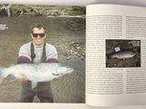 a man holding a fish in a book on a table