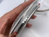 a woman holding a silver cell phone in her hand